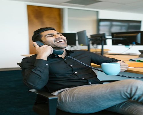 mexican office worker stretching and drinking water at desk